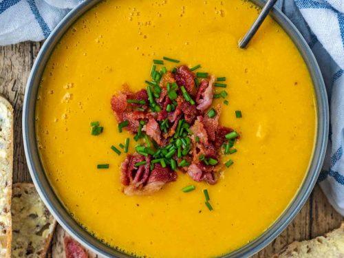 A bowl of butter bean soup topped with bacon and chives.