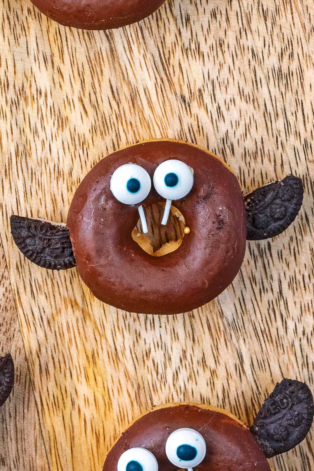 A small chocolate ring doughnut decorated like a vampire bat.