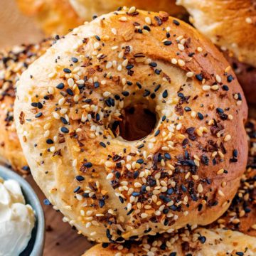 A whole bagel topped with a variety of seeds.