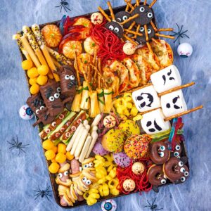 A Halloween Platter on a cobwebbed surface surrounded by spiders and eyeballs.