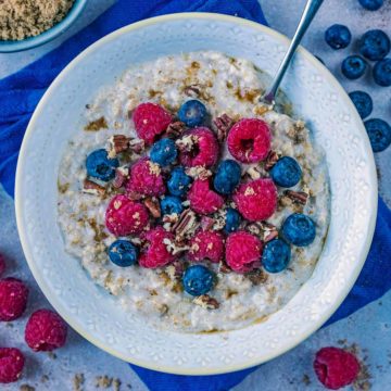 A bowl of microwave porridge topped with berries and crushed nuts.