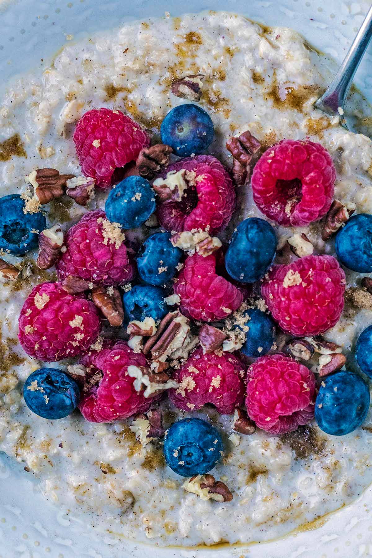 Blueberries, raspberries and crushed pecand on top of some porridge.