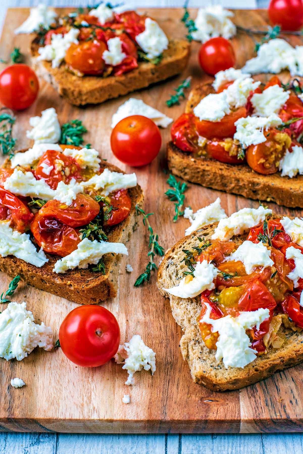 Cherry tomatoes on bread with cheese and thyme.