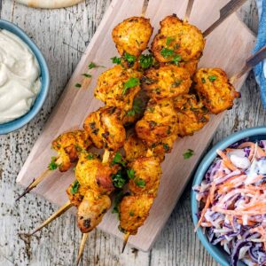 Turkey kebabs on a wooden serving board.