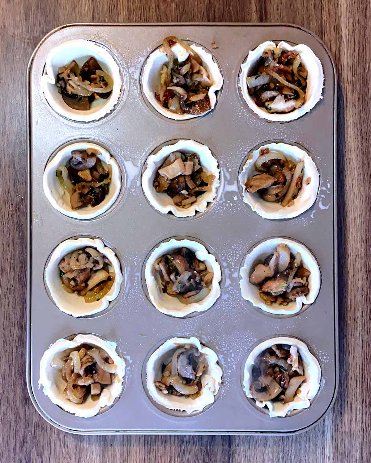 The pastry cups willed with the mushroom mixture.