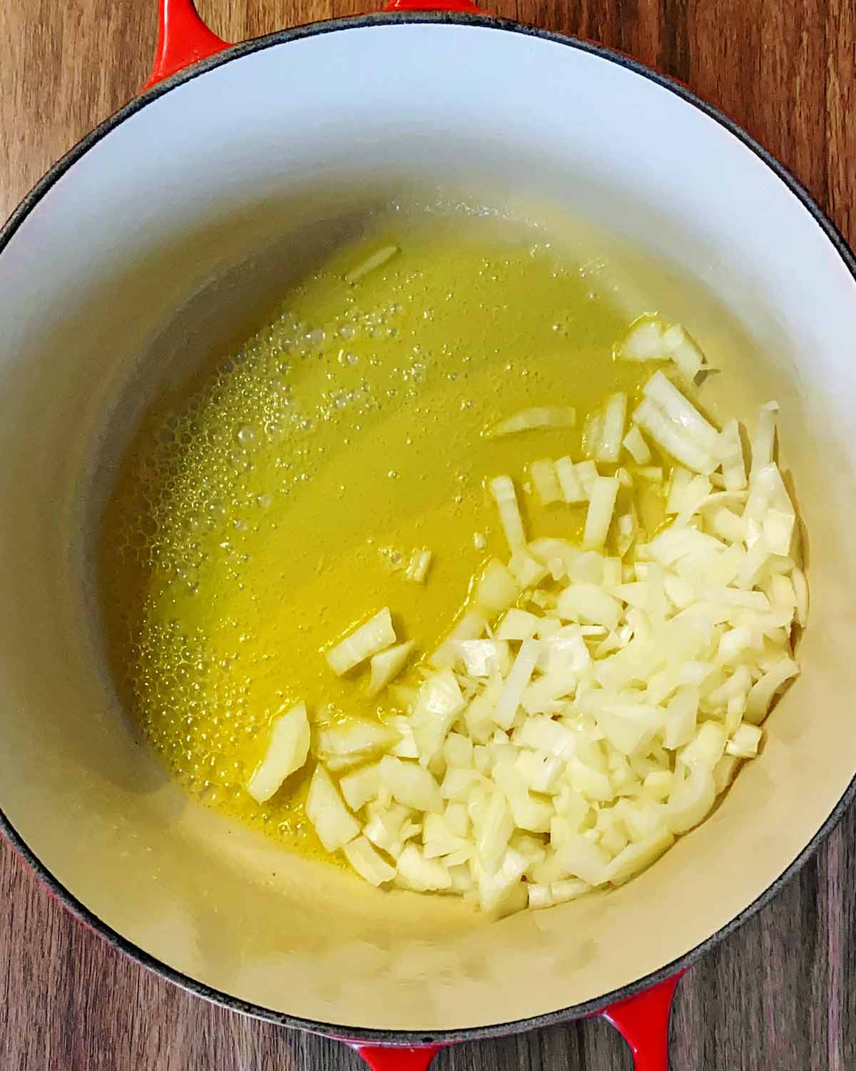 Chopped onions cooking in butter in a large pan.