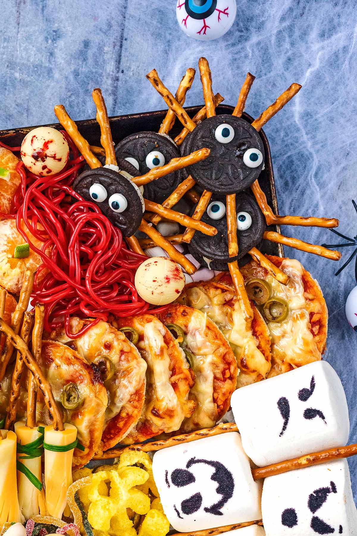 A Halloween platter showing Oreo spiders, pizza slices and large marshmallows.