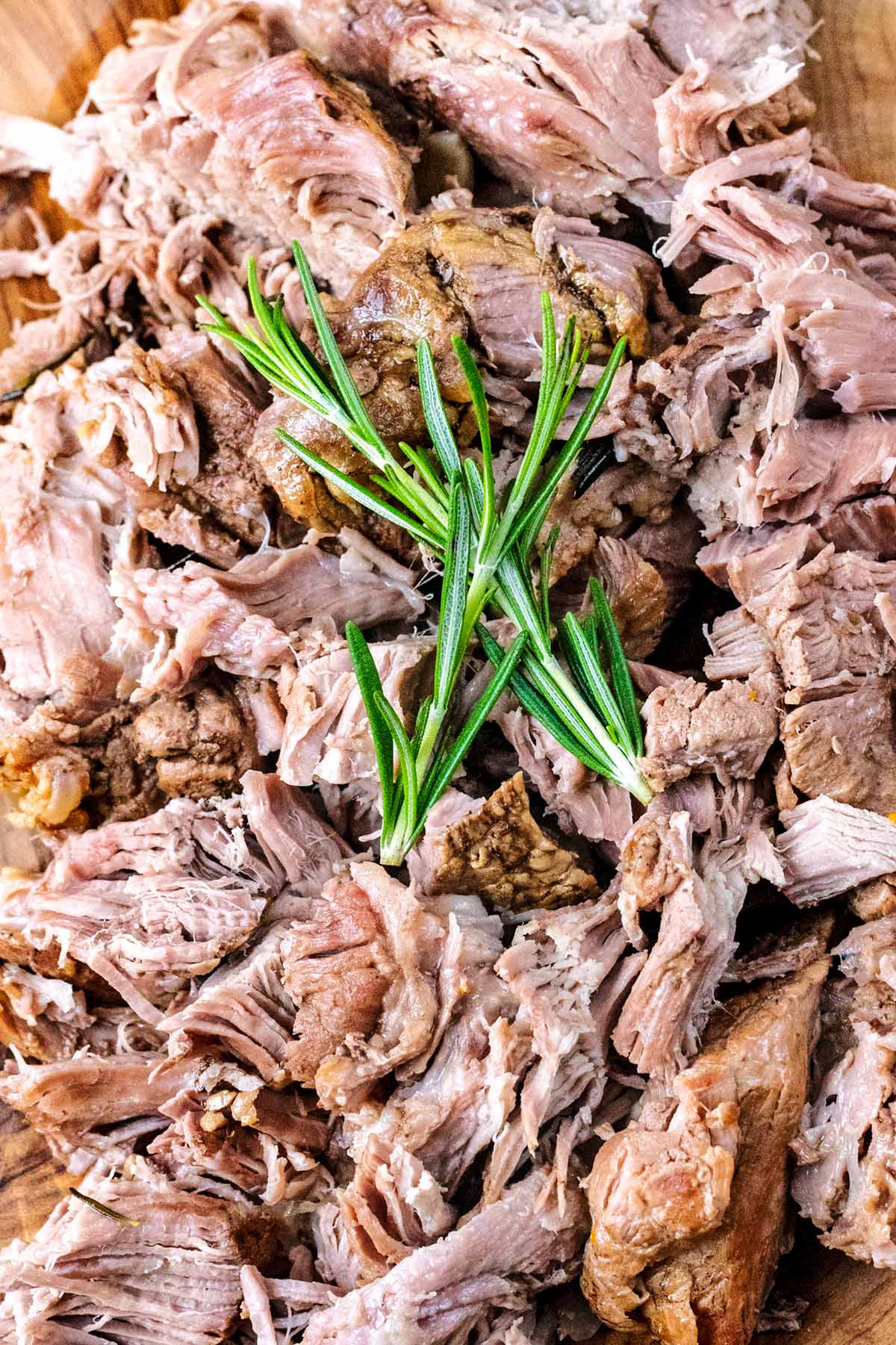 Sliced lamb with two sprigs of rosemary on top.