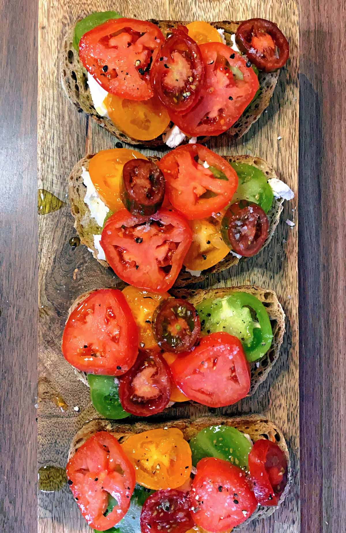 Slices of red, yellow and green tomatoes added to the toast.