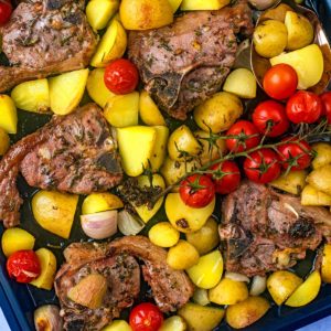 Baked lamb chops with potatoes and tomatoes.