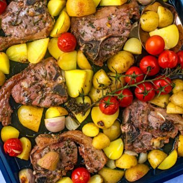 Baked lamb chops with potatoes and tomatoes.