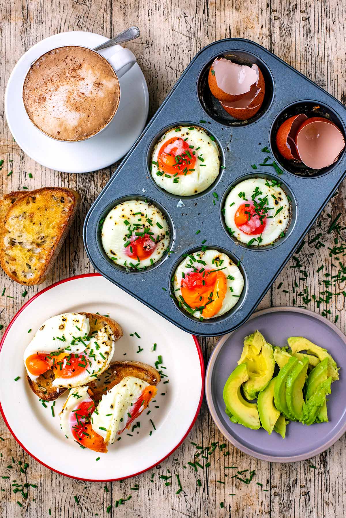 A muffin tin containing cooked eggs next to a plate of more eggs.