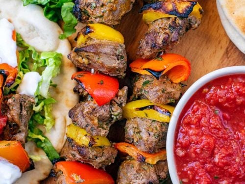 Lamb Shish Kebabs on a wooden serving tray.