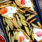 Oven egg and chips on a baking tray.