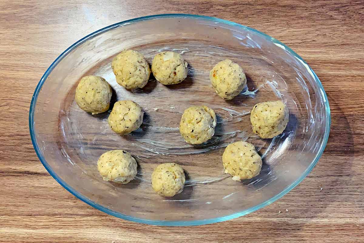 Ten uncooked stuffing balls in a greased baking dish.