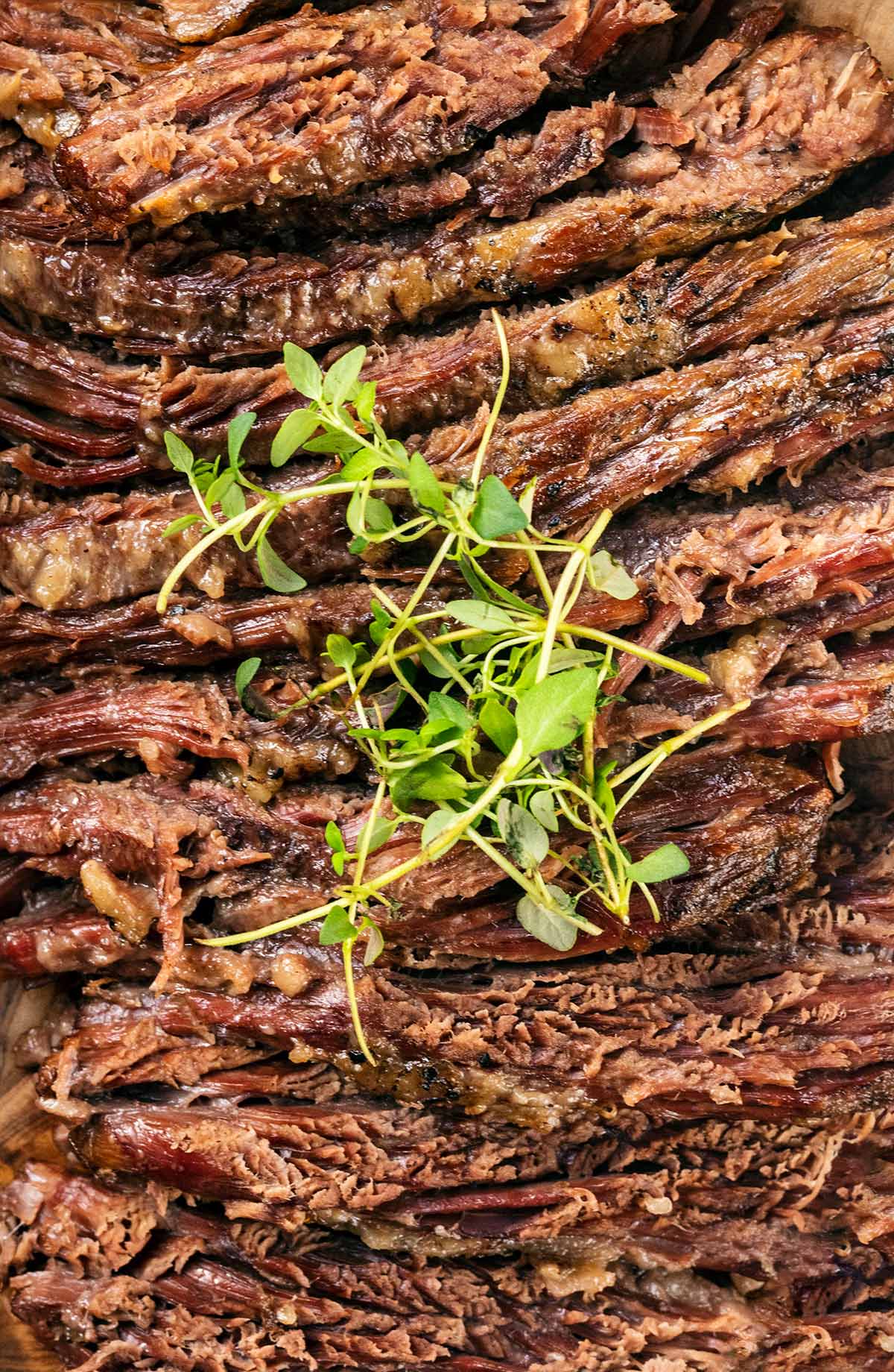 Slices of cooked brisket with a small bunch of cress on top.