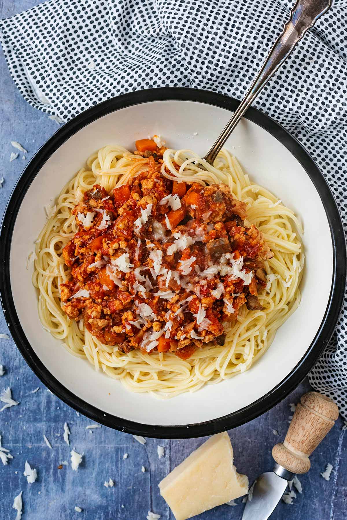 A bowl of bolognese and spaghetti with a spoon in it.