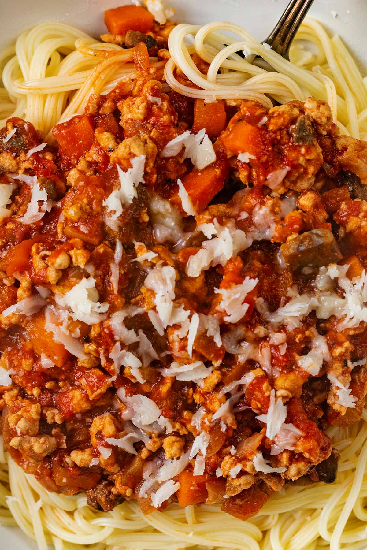 Grated cheese on top of bolognese.
