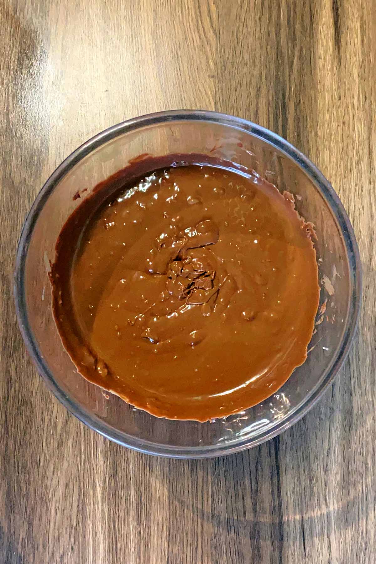 A glass bowl full of melted chocolate.