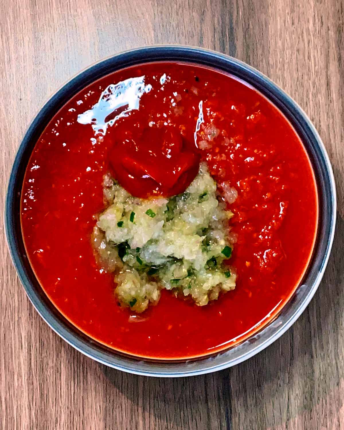 A bowl of chopped tomatoes, garlic paste and ketchup.