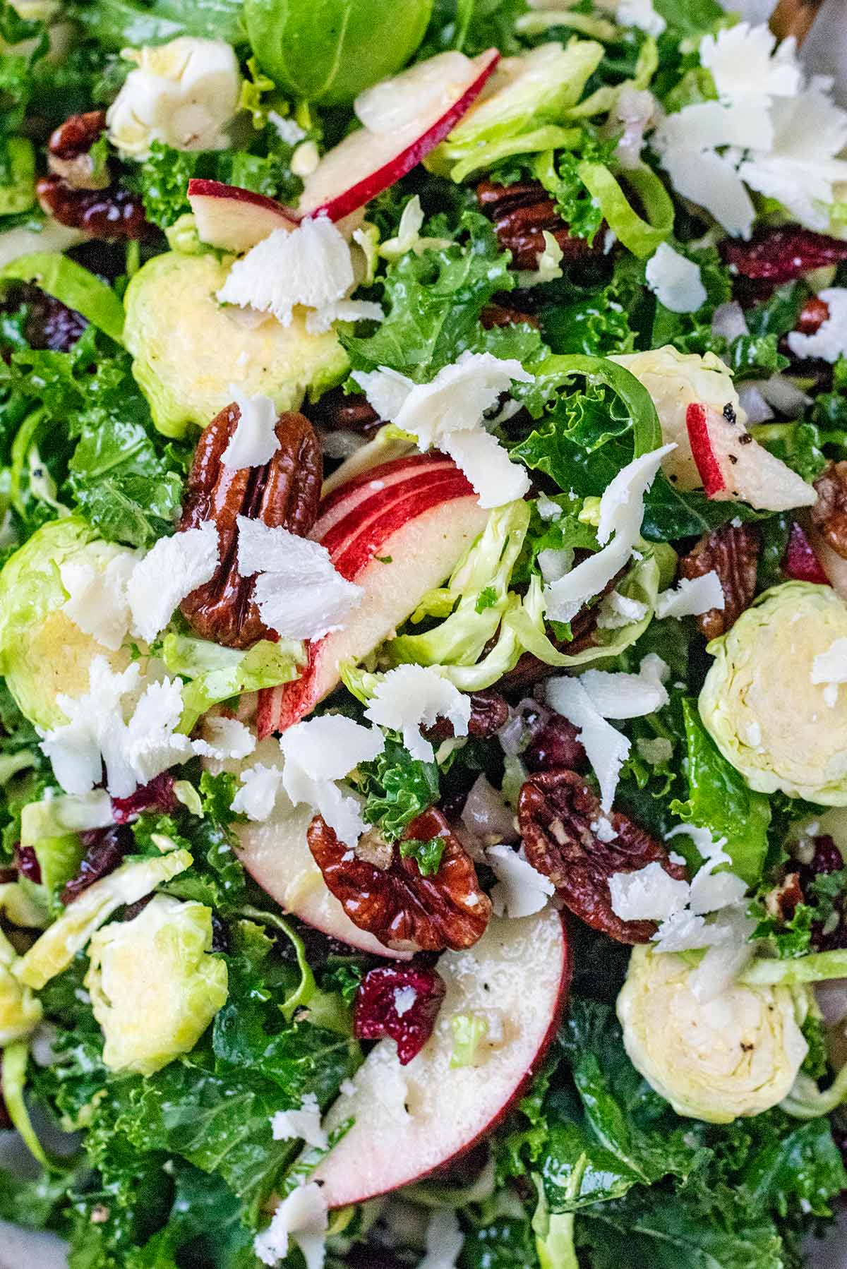 Sliced apples, pecans and Parmesan shavings mixed into salad.