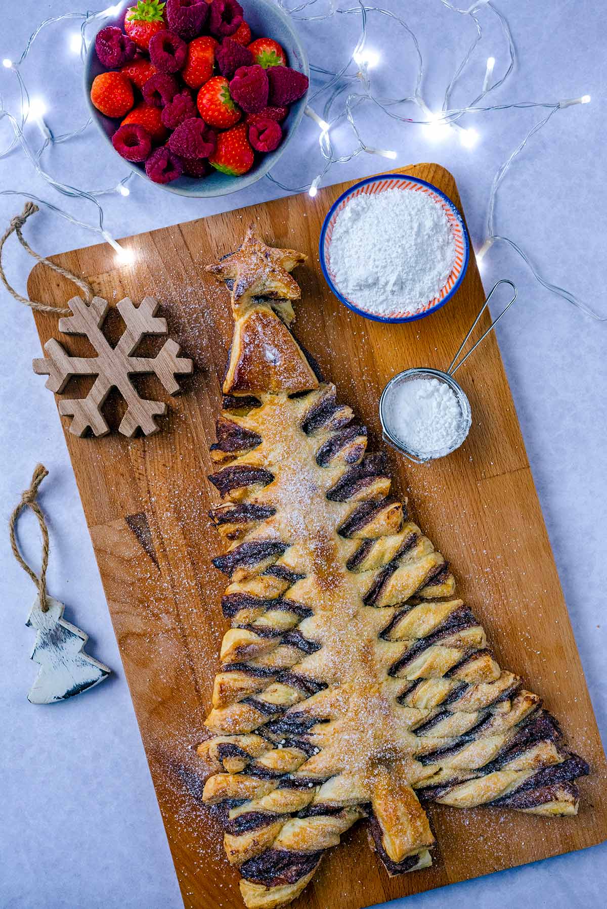 A pastry christmas tree on a wooden serving board.
