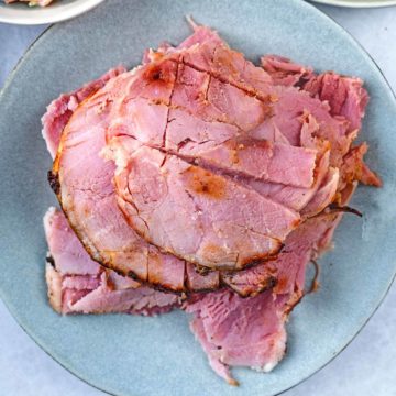 Slices of slow cooker gammon on a blue plate.