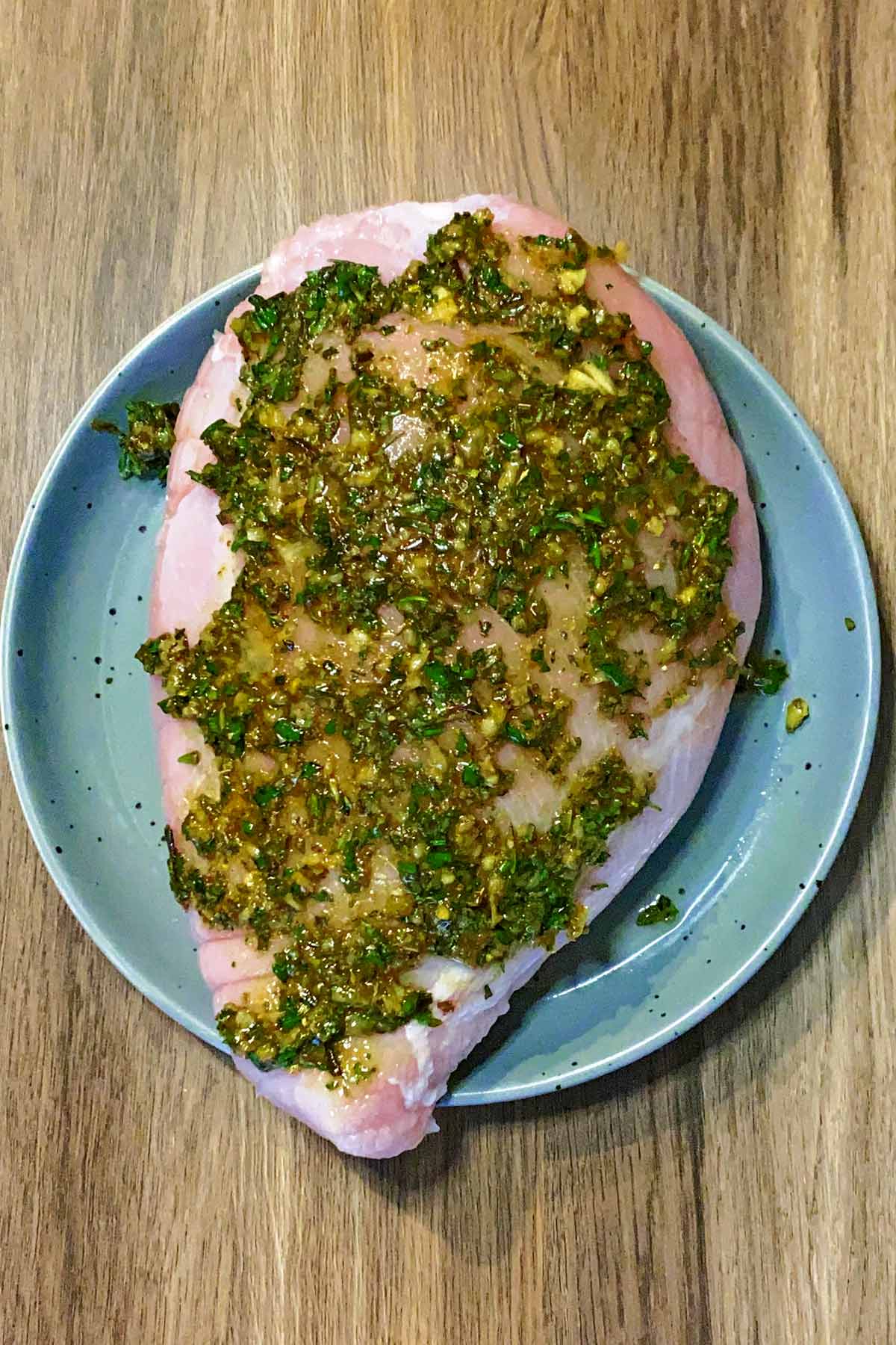 A large turkey breast smothered in marinade.