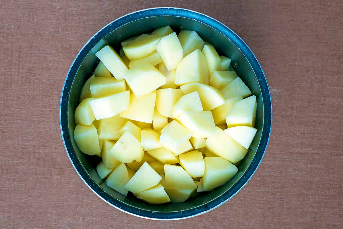 A saucepan containing chopped potatoes.