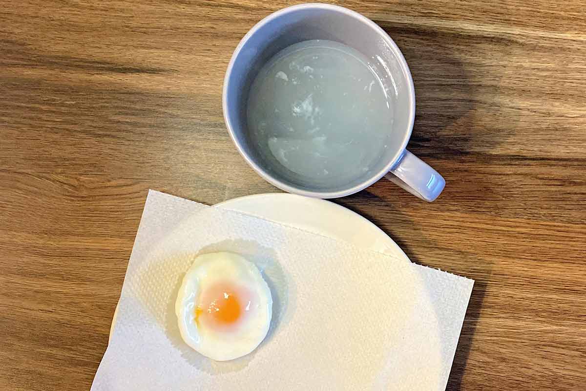 The poached egg removed from the mug and put on some kitchen paper.