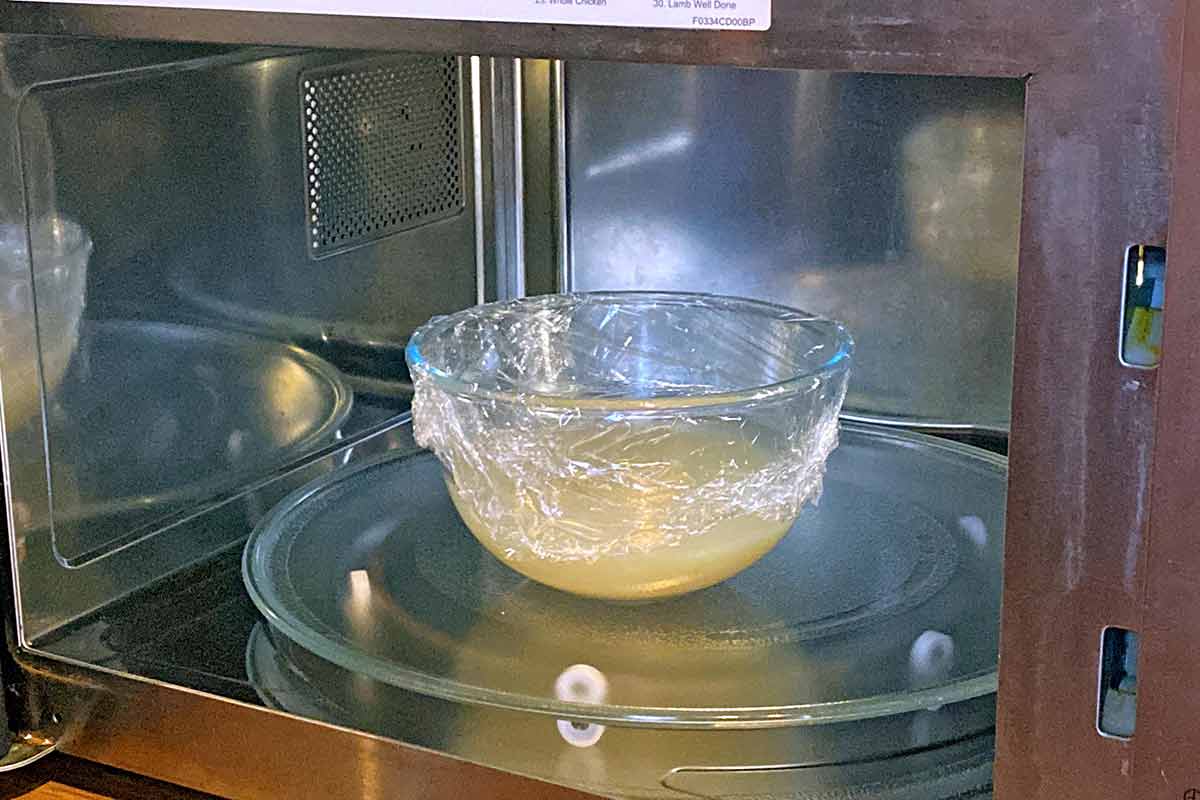 Interior of a microwave with a bowl of rice in water.