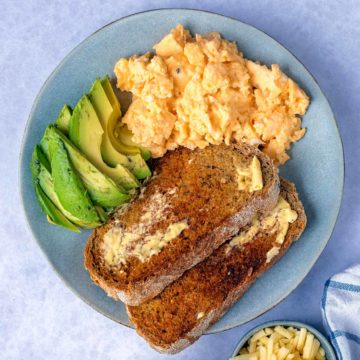 Microwave scrambled eggs on a plate with avocado and toast.