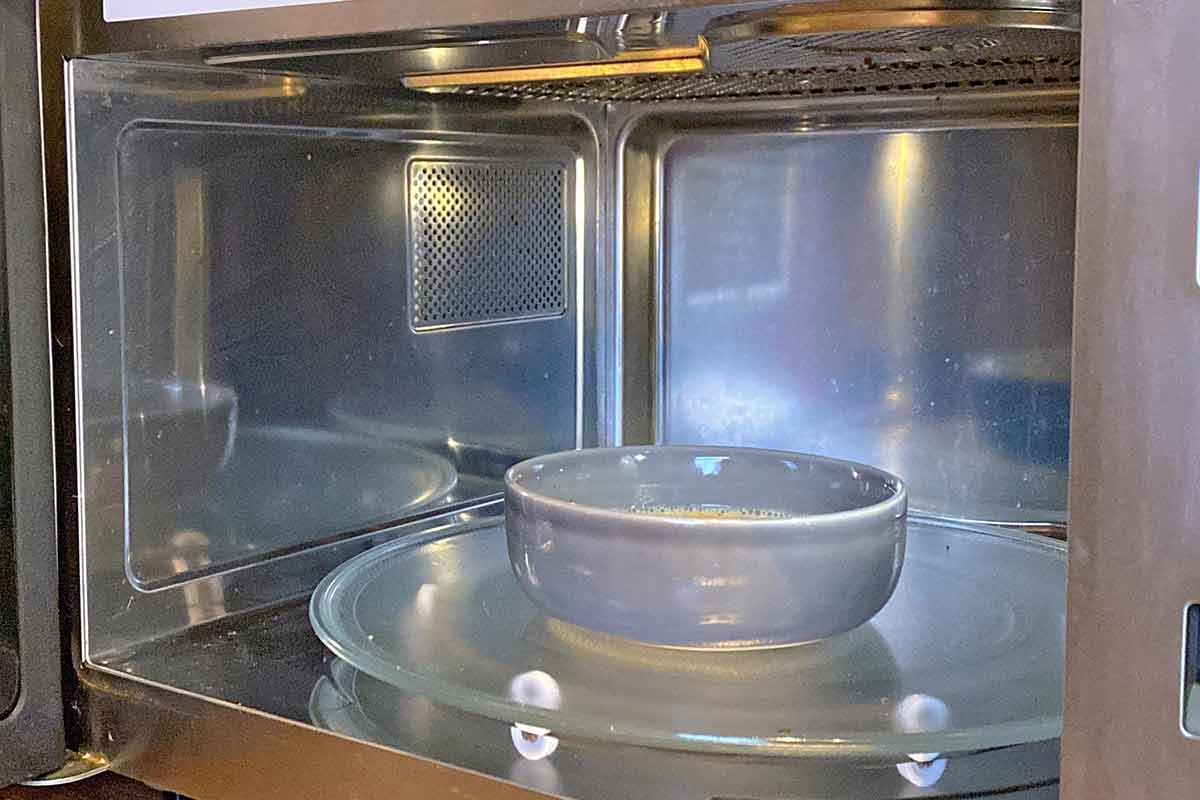 Interior of a microwave with a bowl in it.