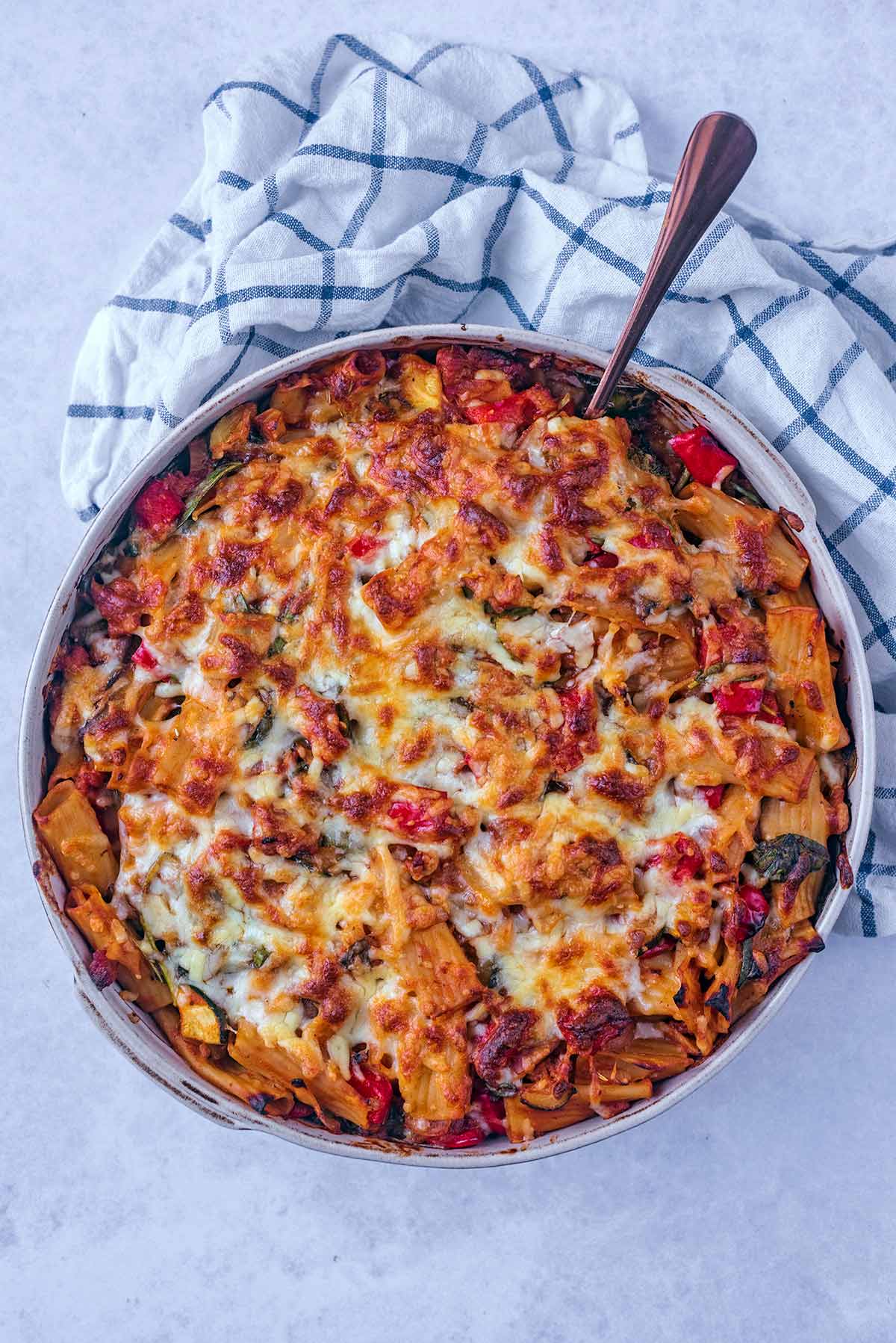 A large serving dish full of sausage pasta bake.