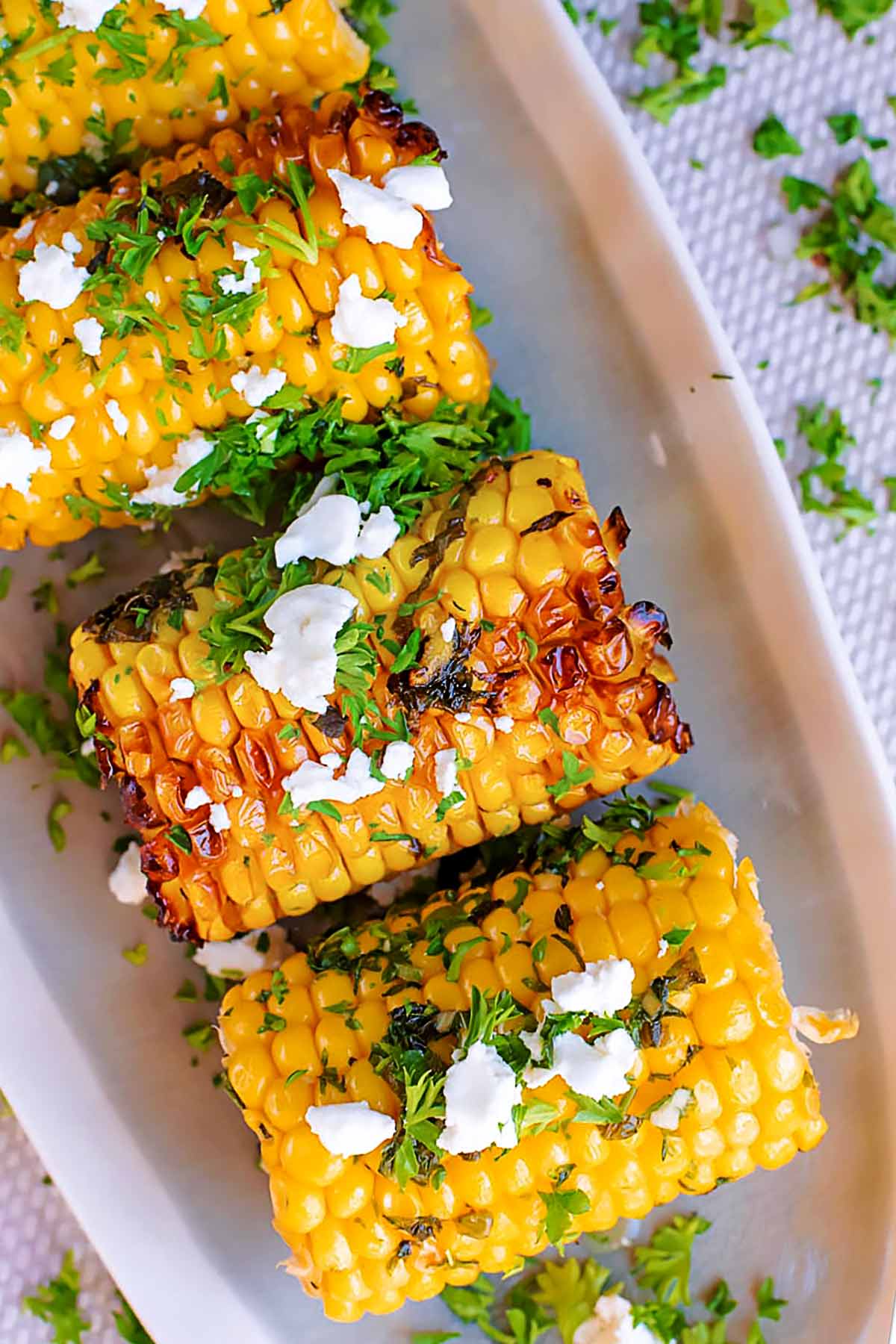 Grilled corn on the cob on a long serving dish.