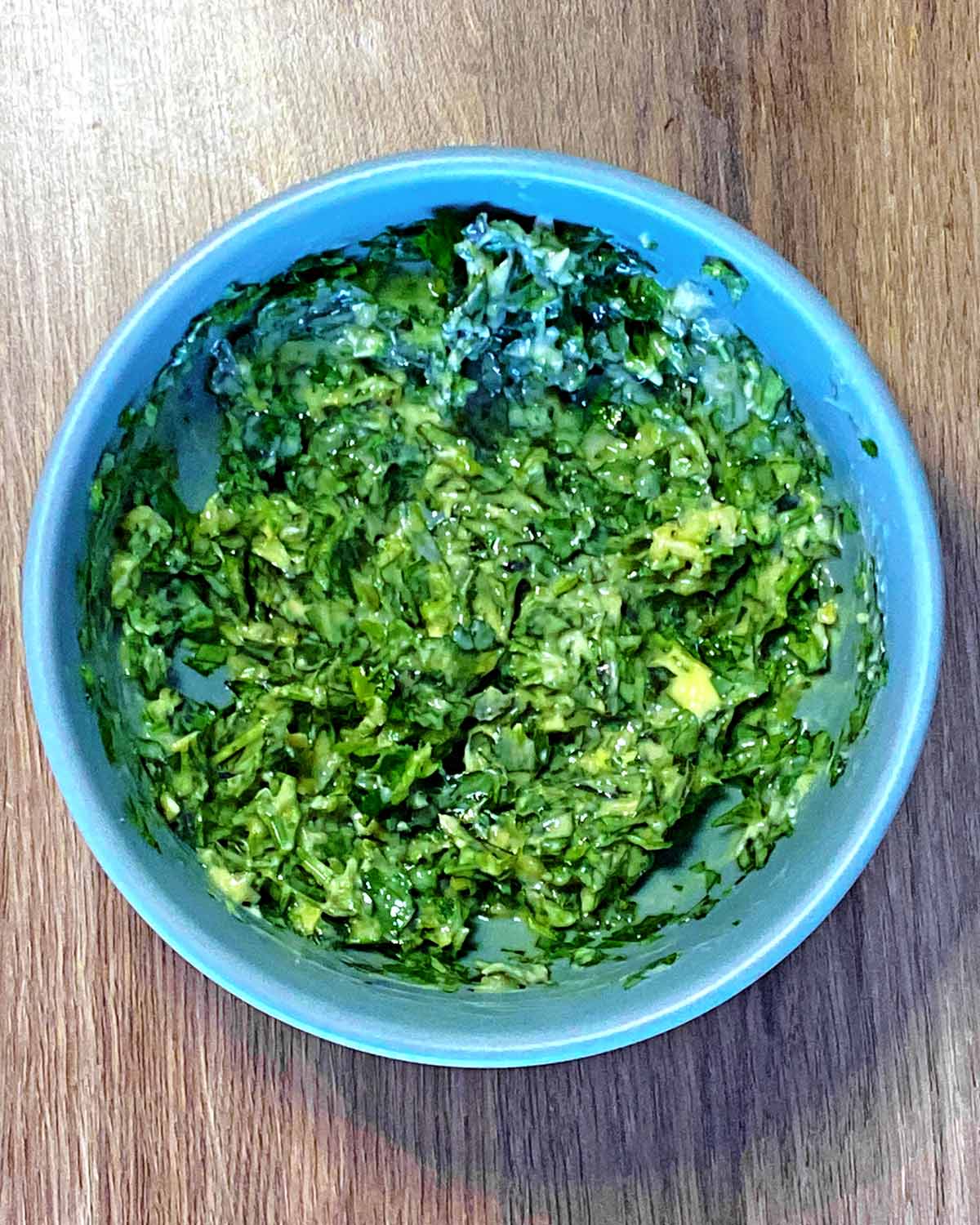 A bowl containing butter and herbs mixed together.