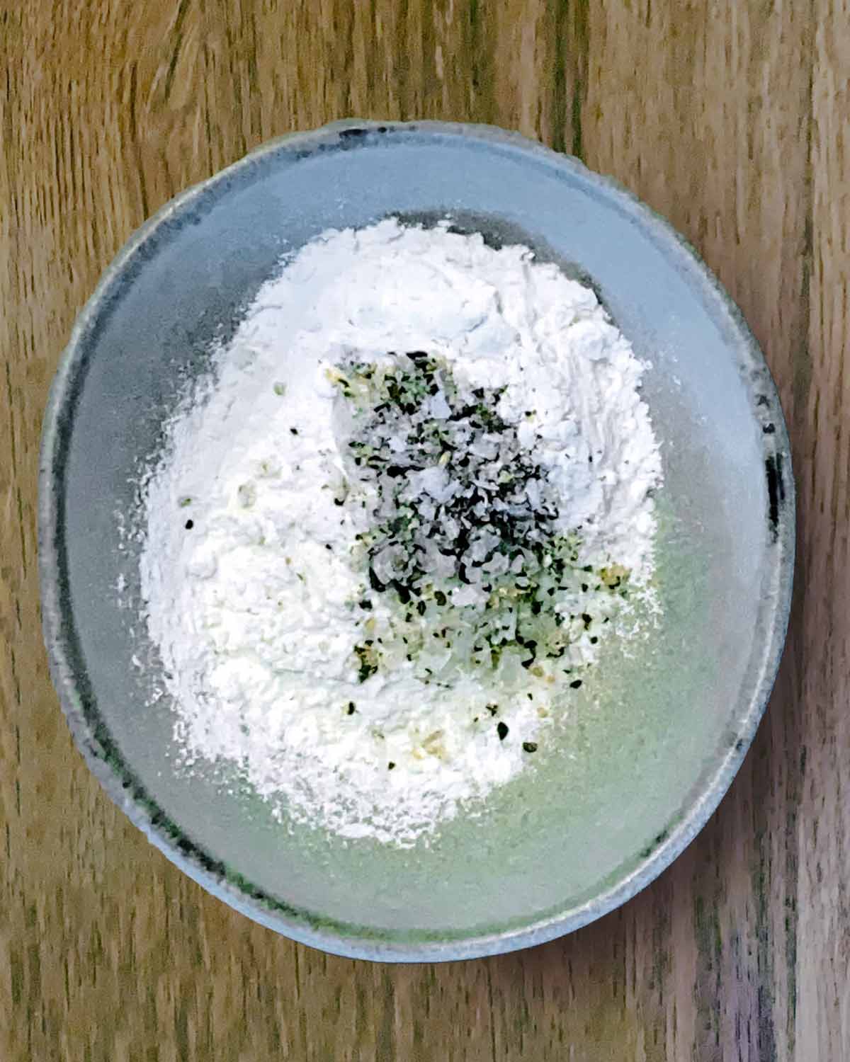 A bowl of flour, salt and pepepr.