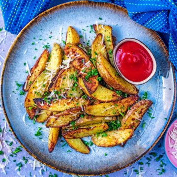 Air Fryer Potato Wedges and ketchup on a blue plate.