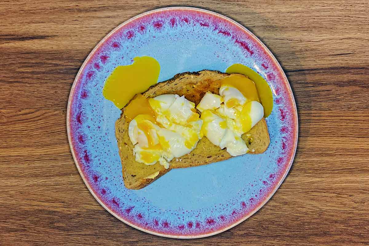 The eggs smashed open and the yolks running over the toast and plate.