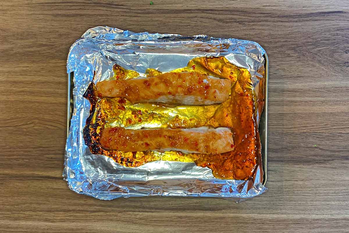 Cooked salmon fillets on a baking tray.