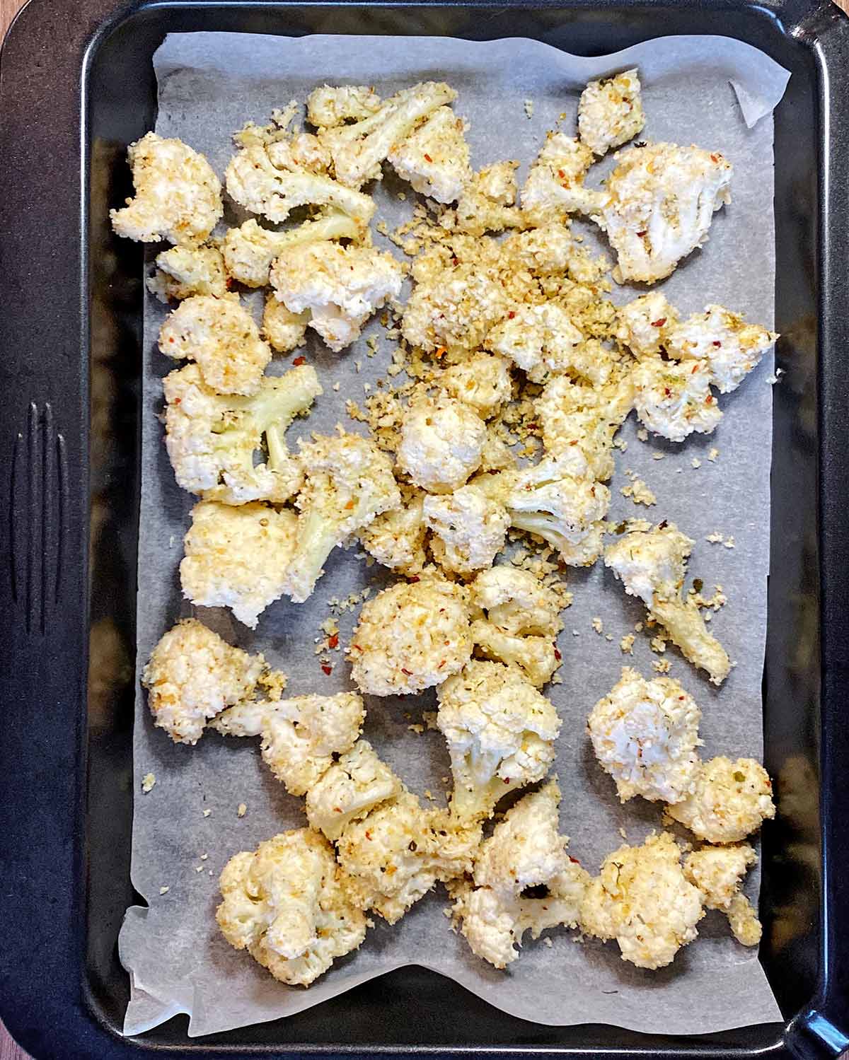 The coated breadcrumbs on a lined baking sheet.