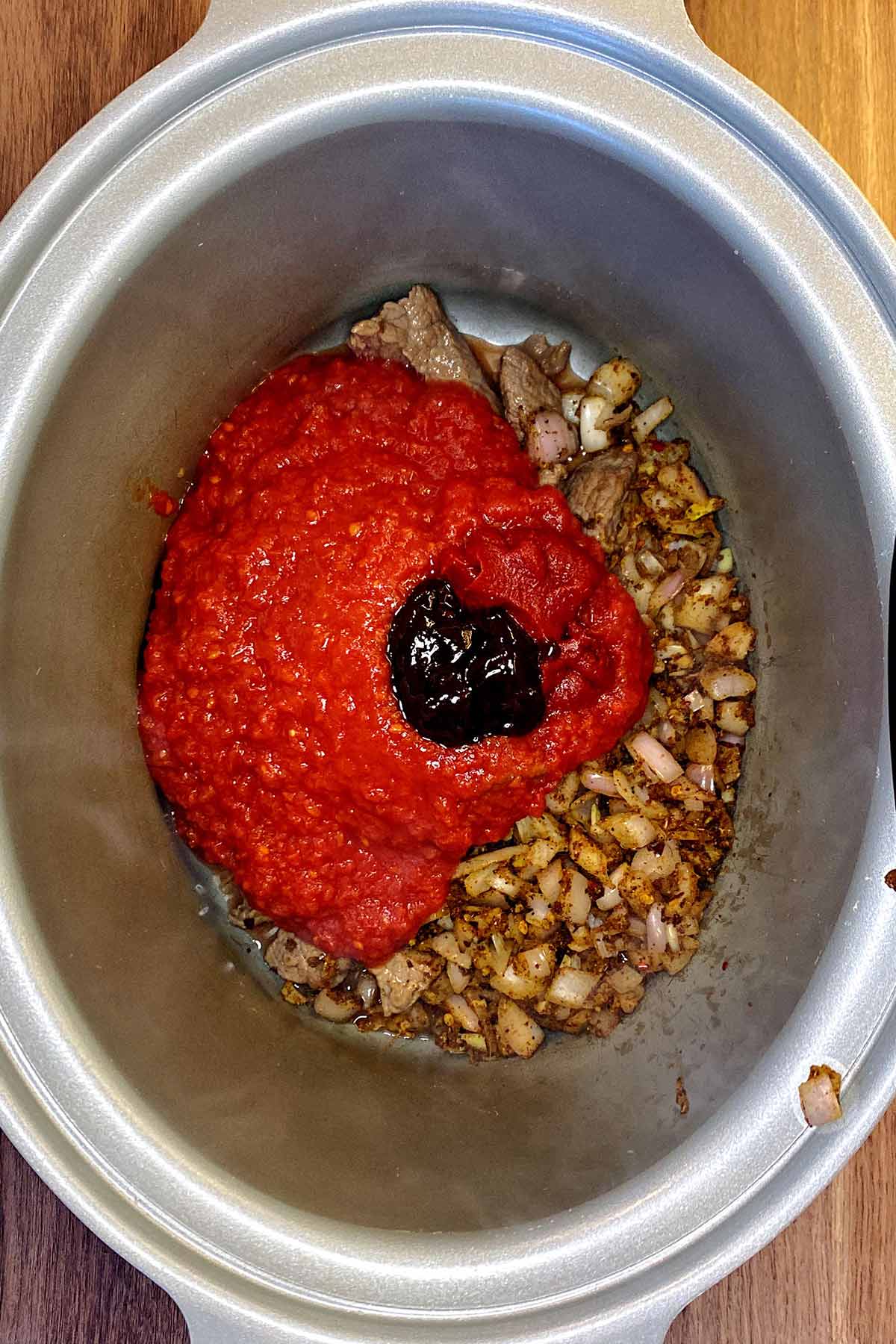 Chopped tomatoes and stock added to the slow cooker.