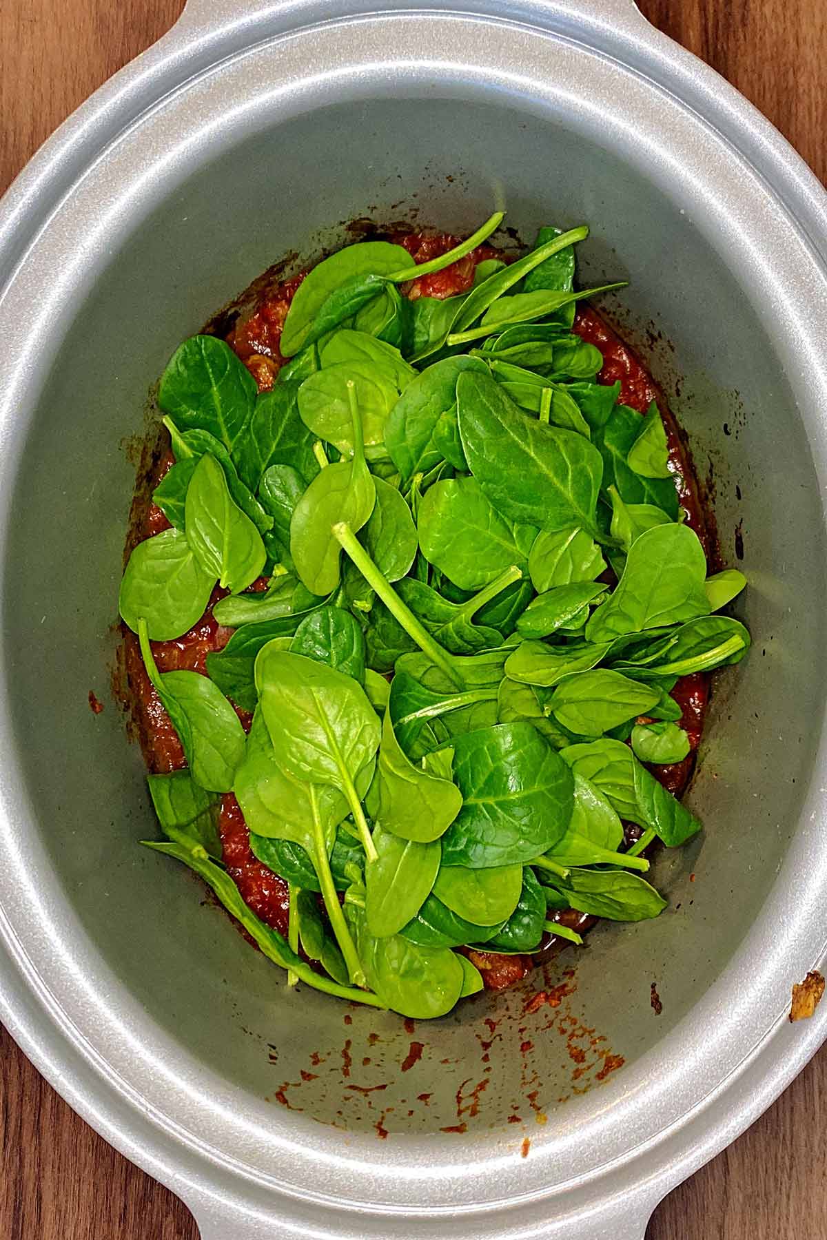 Spinach and coriander leaves added to the slow cooker.