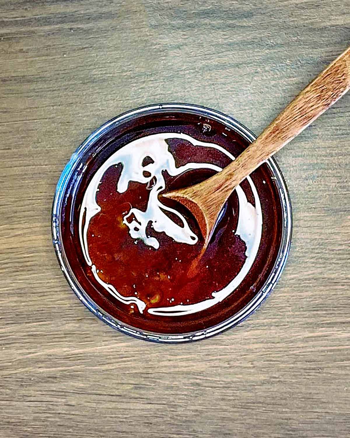 A small bowl of sweet chilli sauce and soy sauce mixed together.