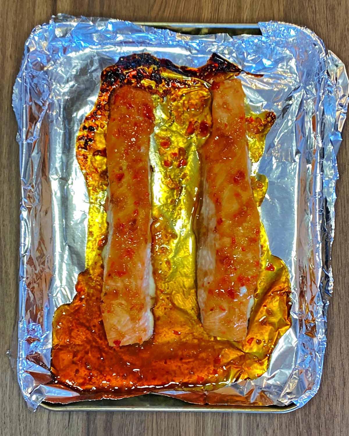 Cooked salmon fillets on a baking tray.