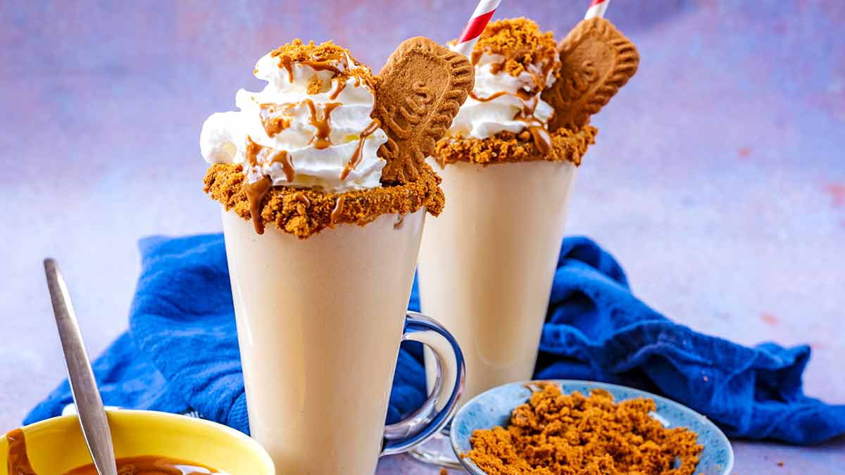 Milkshakes topped with cream and biscuits.