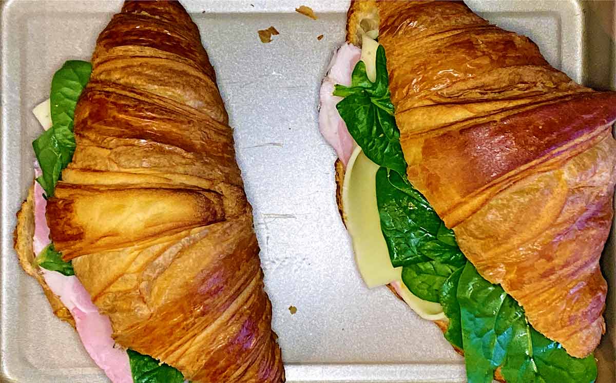 Two stuffed croissants on a baking tray.