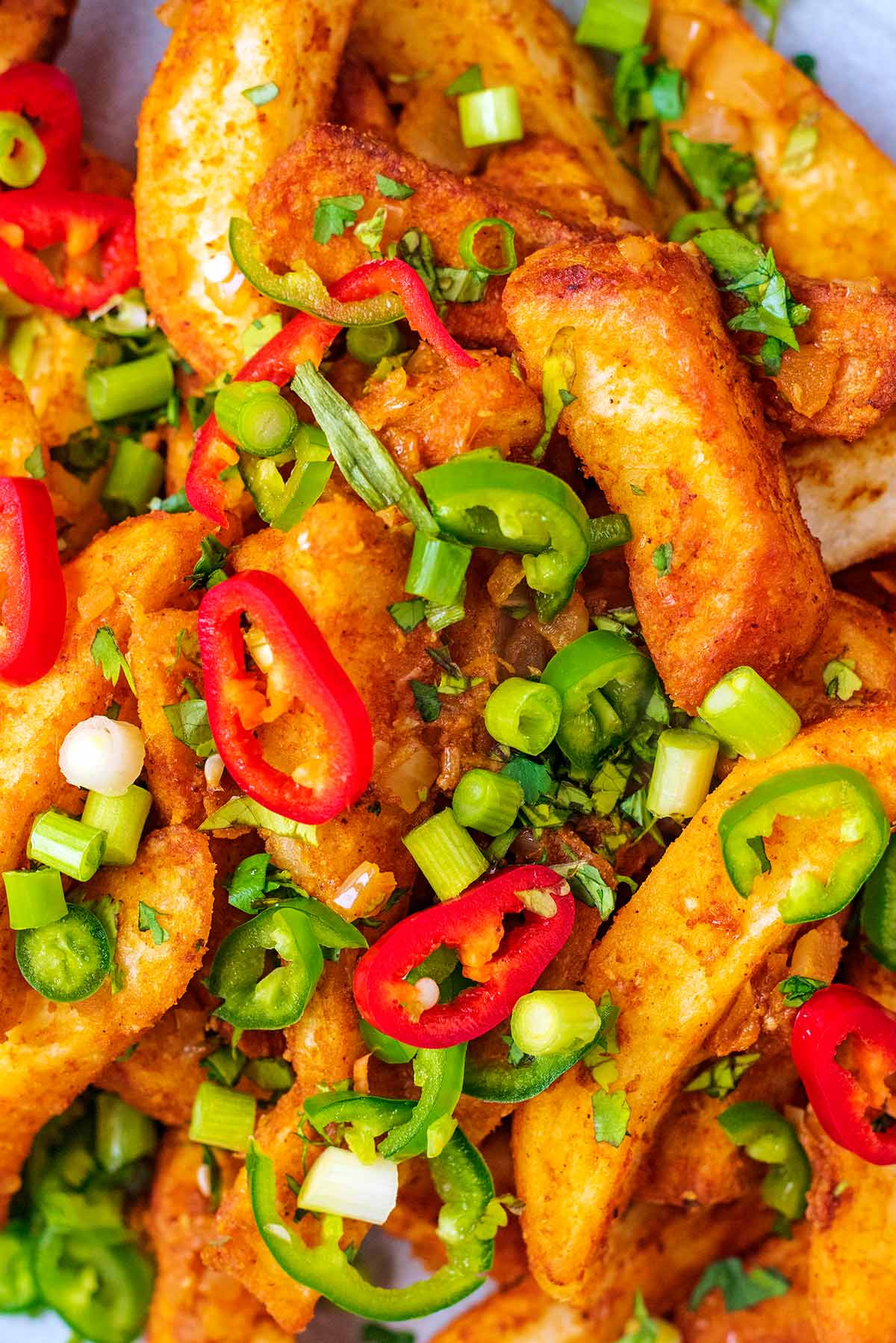 Masala chips topped with sliced chillies and chopped spring onions.