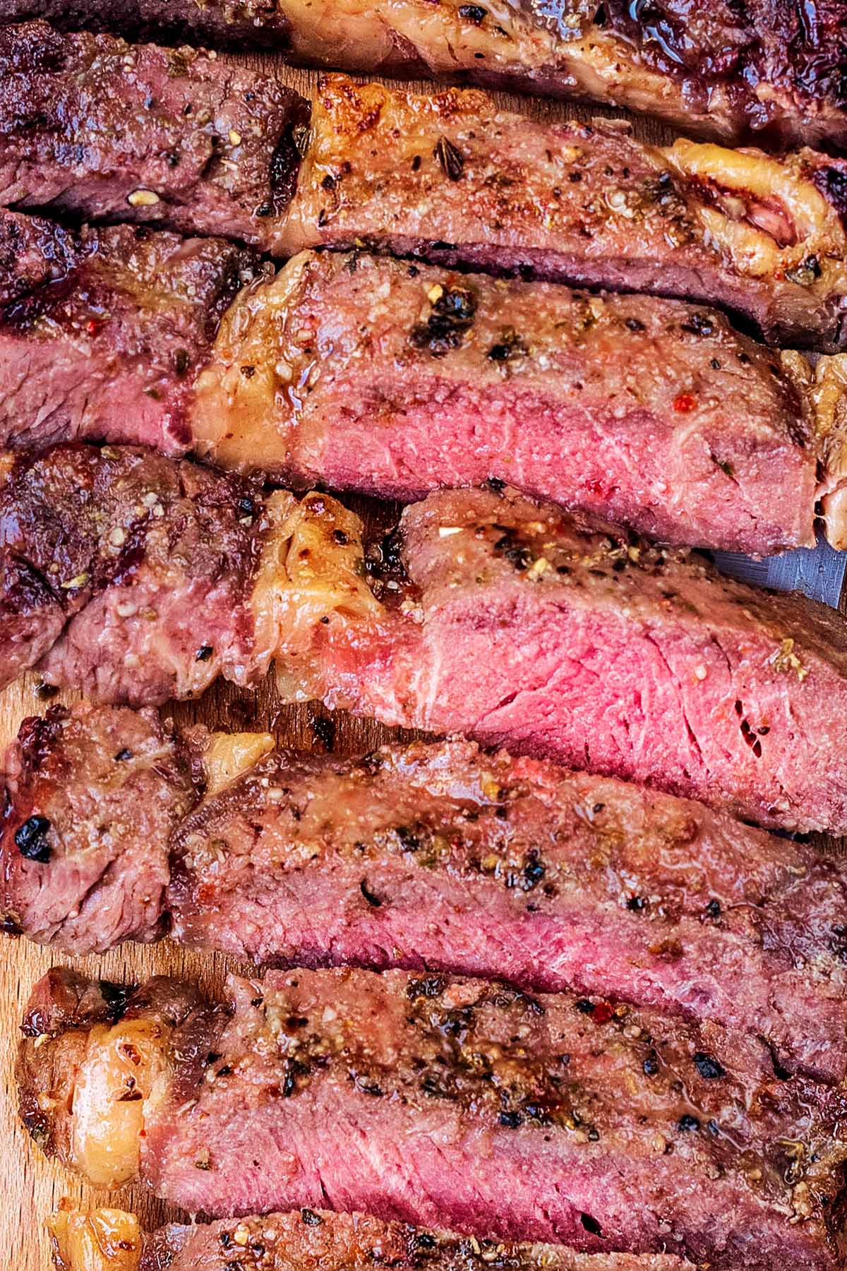 Strips of cooked steak showing a pink middle.