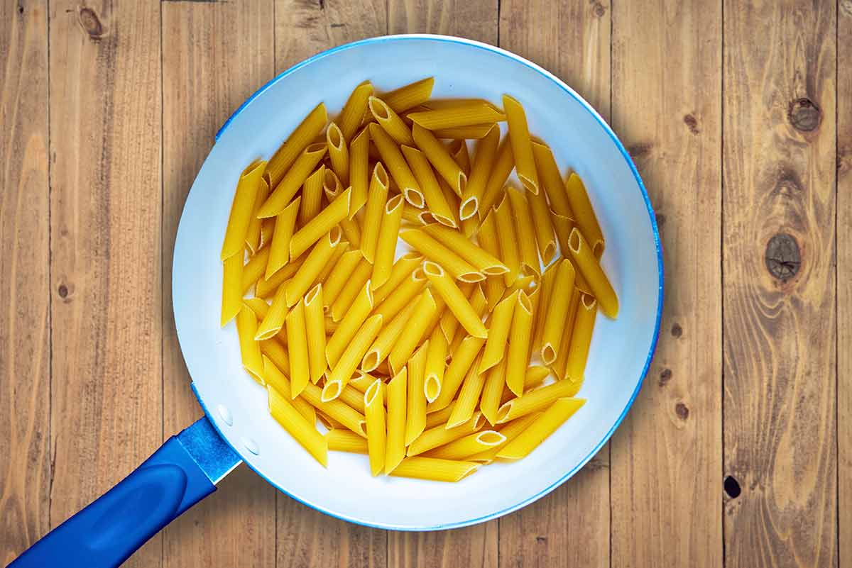 a saucepan full of uncooked penne pasta.